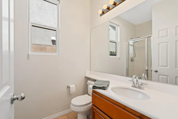 a bathroom with a granite countertop sink toilet and a mirror