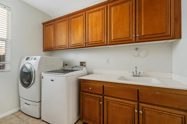a utility room with sink dryer and washer