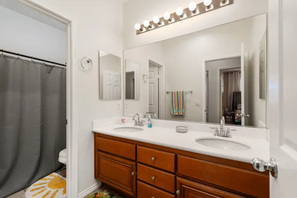 a bathroom with double vanity sink and a mirror