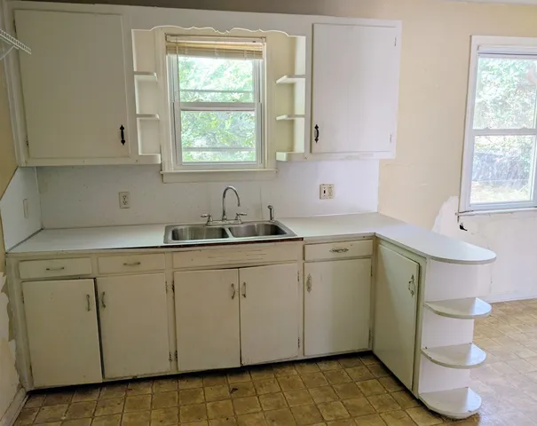 a kitchen with a sink cabinets and a window