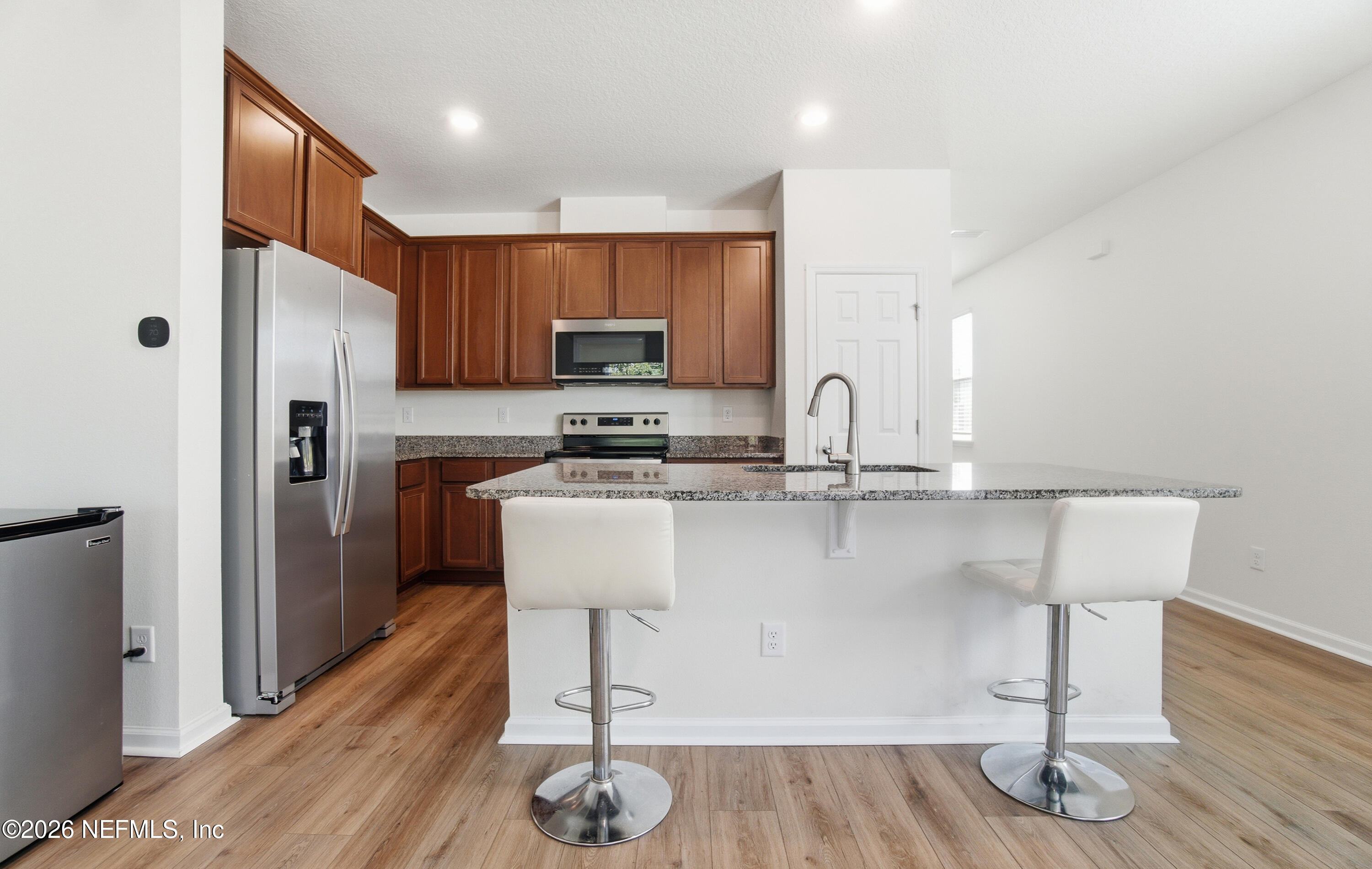 7662 Merchants Way Jacksonville, FL 32222 - Photo 8 of 32 a kitchen with kitchen island granite countertop a sink cabinets and refrigerator