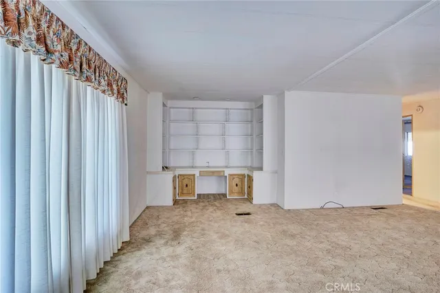 an empty room with closet and windows