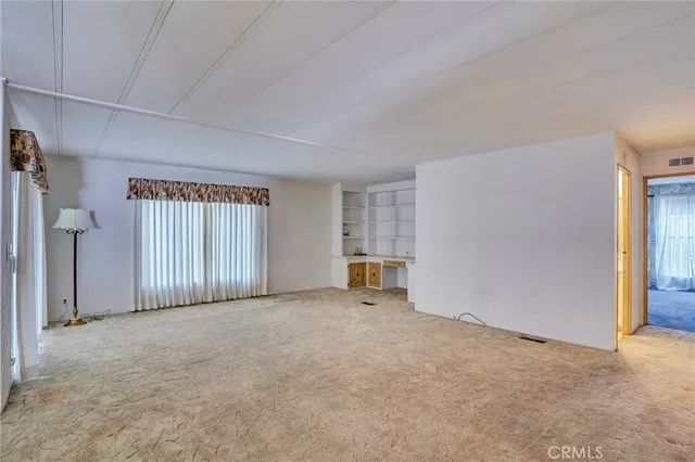 an empty room with closet and a ceiling fan