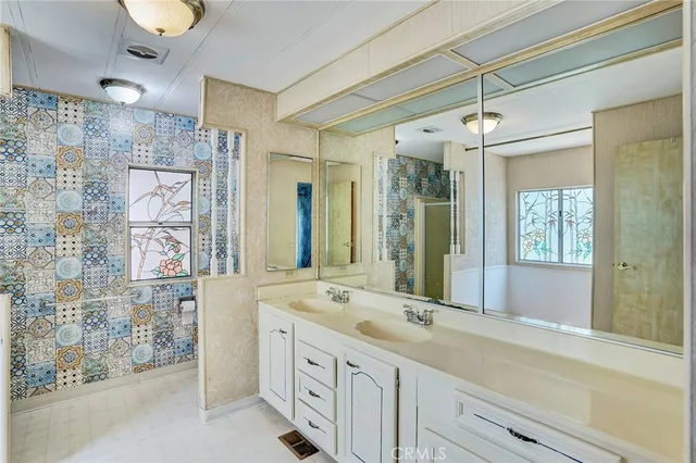 a bathroom with a granite countertop sink a toilet and shower