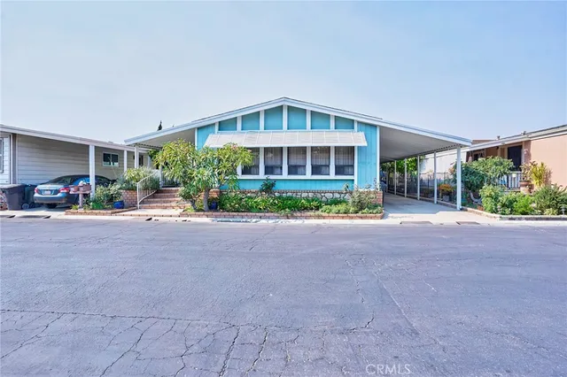 a view of a house with a big yard and large trees