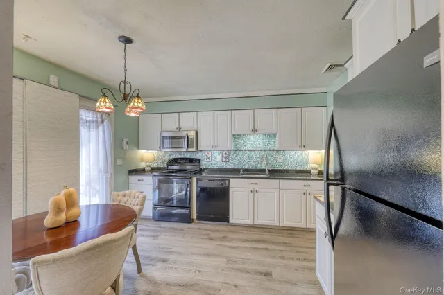 a kitchen with stainless steel appliances granite countertop a sink a stove a refrigerator and island