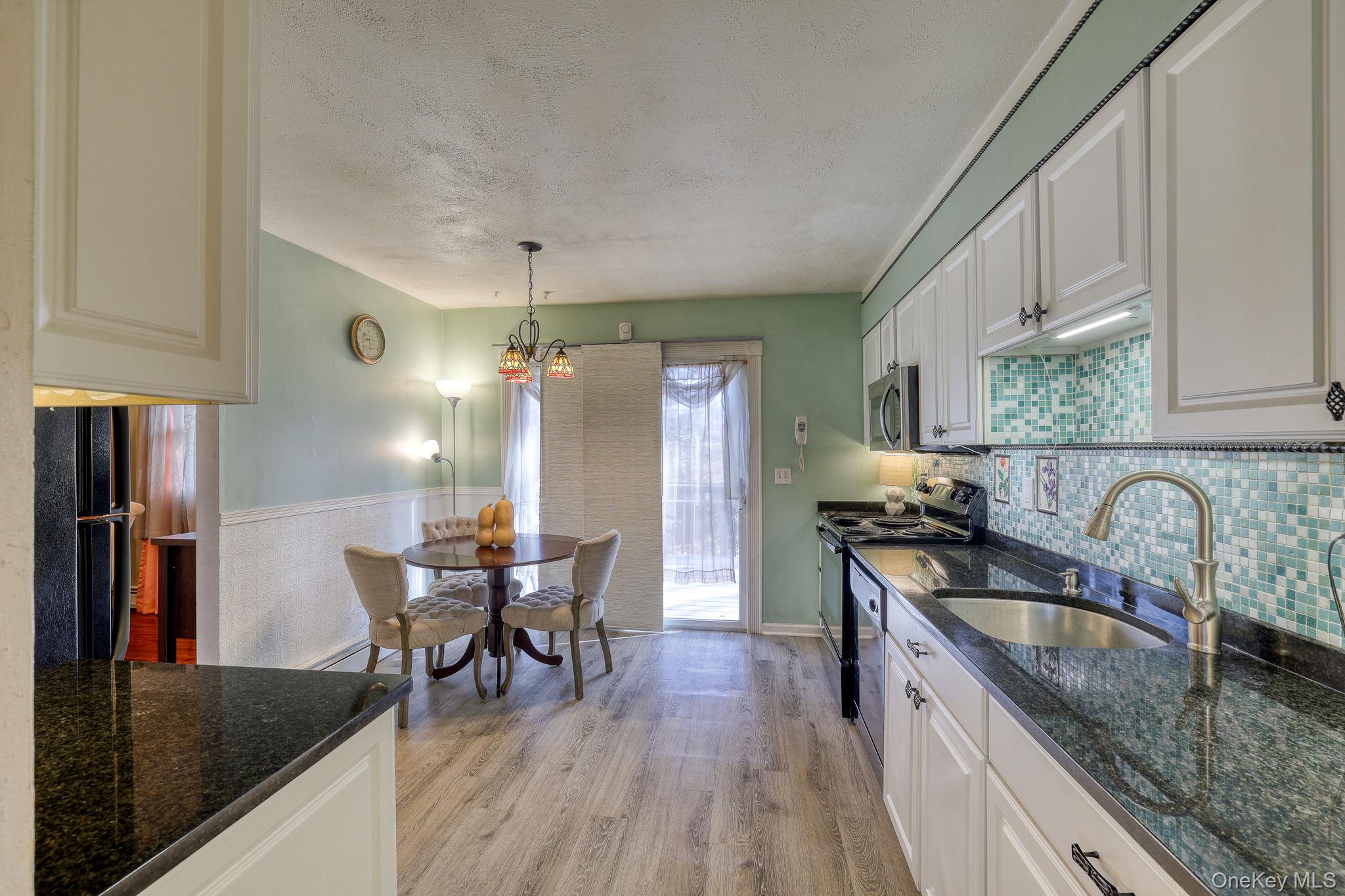 1 Townsend Street New Windsor, NY 12553 - Photo 14 of 36 a kitchen with granite countertop a dining table chairs stove and refrigerator
