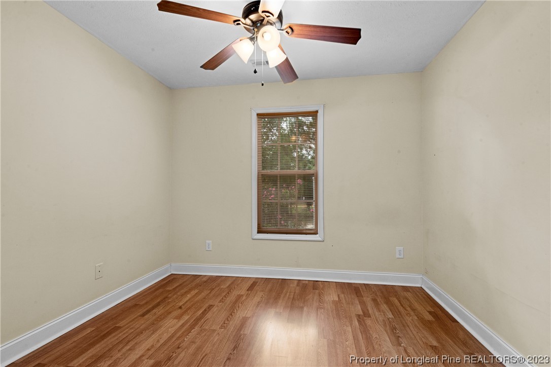 185 King Road Fayetteville, NC 28306 - Photo 19 of 24 an empty room with wooden floor chandelier fan and windows