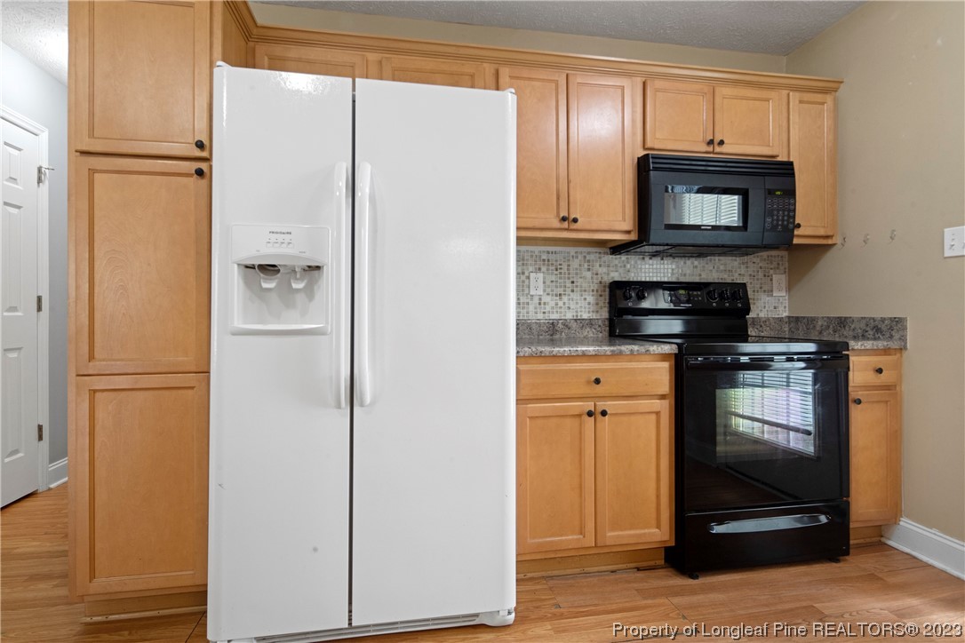 185 King Road Fayetteville, NC 28306 - Photo 7 of 24 a kitchen with granite countertop a refrigerator and a stove