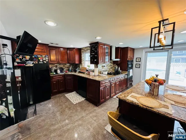 a kitchen with a refrigerator and a stove top oven
