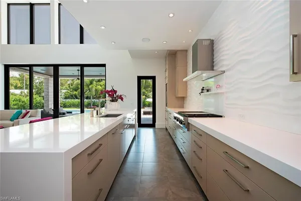 a large white kitchen with a large window