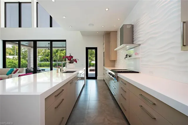 a large white kitchen with a large window