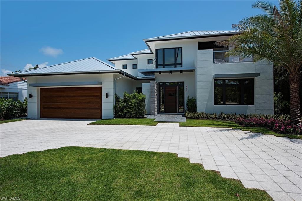688 3rd Street North Naples, FL 34102 - Photo 2 of 33 a front view of a house with a yard and garage