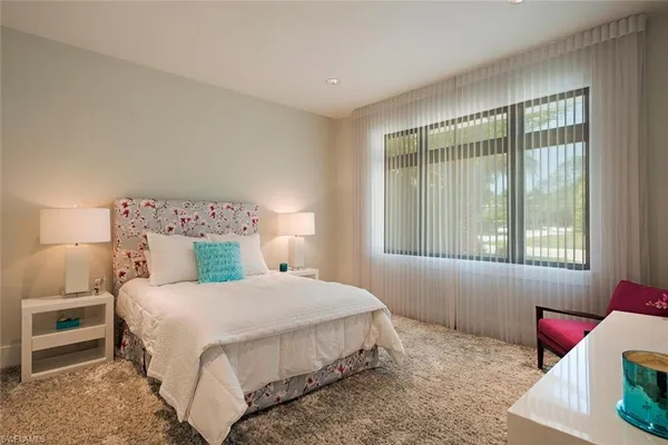 a bedroom with a bed and windows