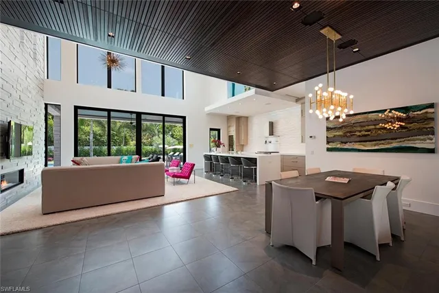 a living room with couches a dining table and chairs with outer view