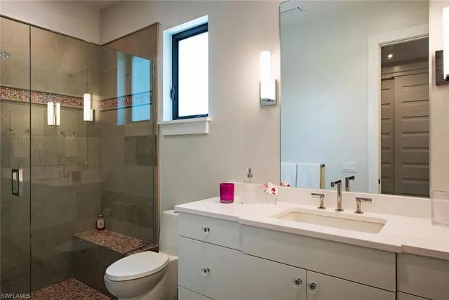 a bathroom with a sink toilet vanity and shower