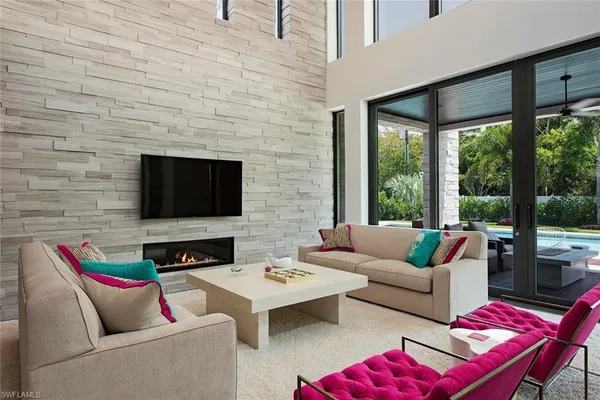 a living room with furniture a flat screen tv and a fireplace