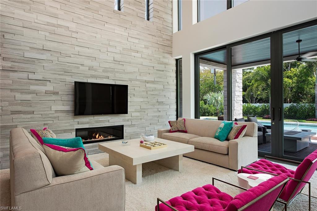 688 3rd Street North Naples, FL 34102 - Photo 9 of 33 a living room with furniture a flat screen tv and a fireplace