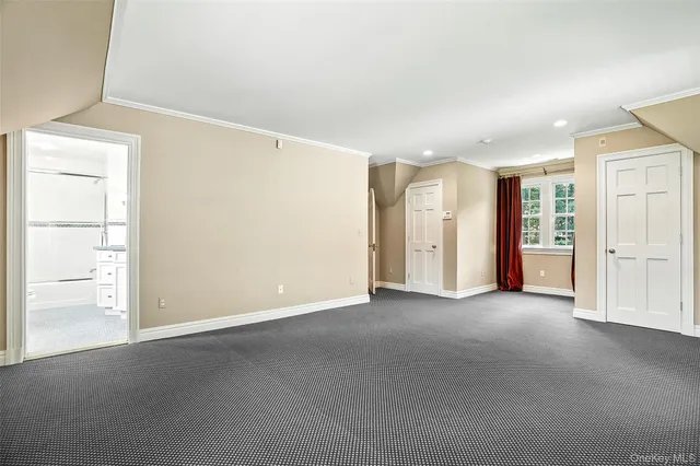an empty room with closet and windows