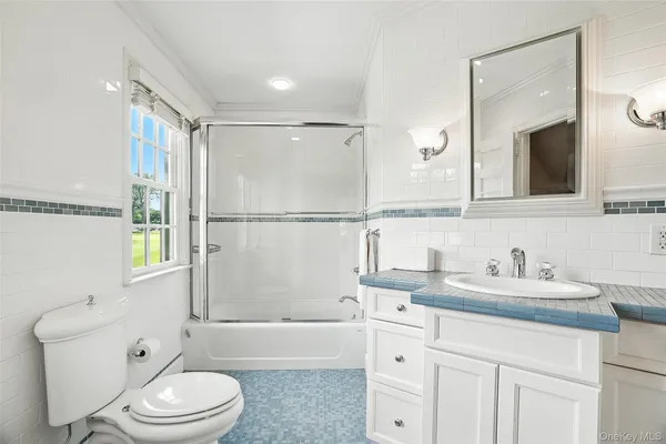 a bathroom with a sink a toilet a mirror and shower