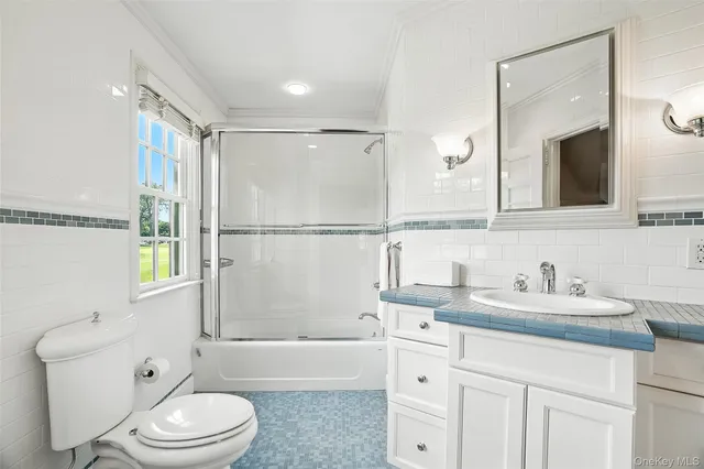 a bathroom with a sink a toilet a mirror and shower