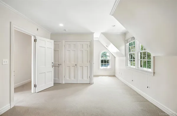 an empty room with windows and closet