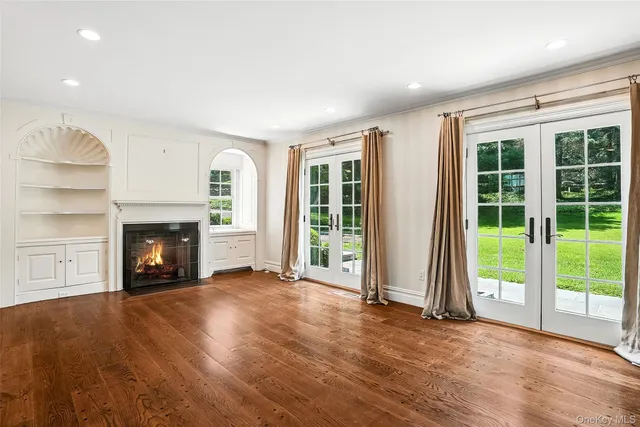 a view of an empty room with a window and fireplace