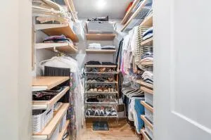 a view of walk in closet with clothes and shoes