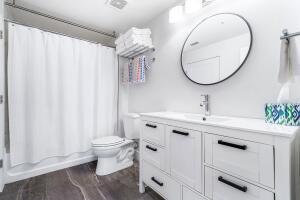 250 Northeast 3rd Avenue, Unit 1510 Delray Beach, FL 33444 - Photo 25 of 50 a bathroom with a sink a mirror and a toilet