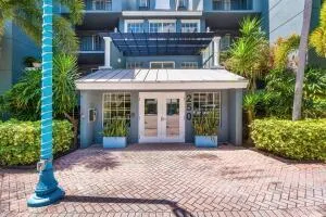 a view of a house with a small yard plants and large tree