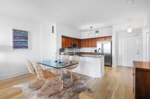 250 Northeast 3rd Avenue, Unit 1510 Delray Beach, FL 33444 - Photo 41 of 50 a kitchen with a dining table chairs and refrigerator