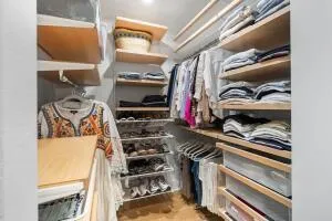 a view of walk in closet with clothes and shoes