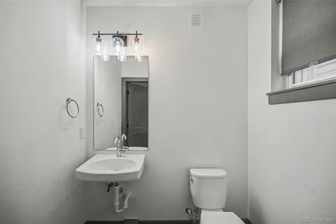 a bathroom with a sink a toilet and mirror