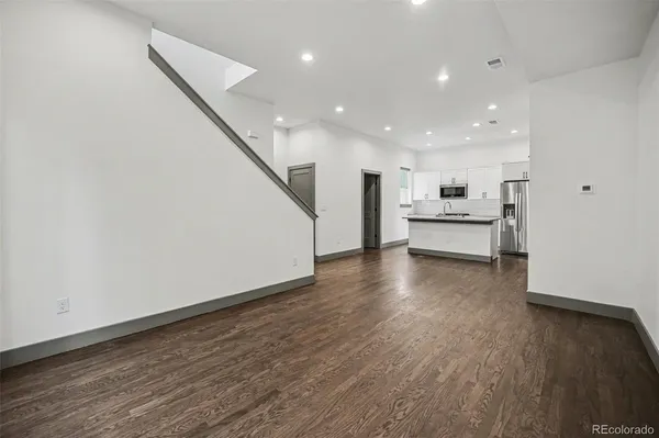 a view of a kitchen with wooden floor and electronic appliances