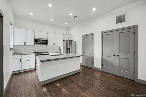a kitchen with stainless steel appliances a refrigerator and a stove top oven