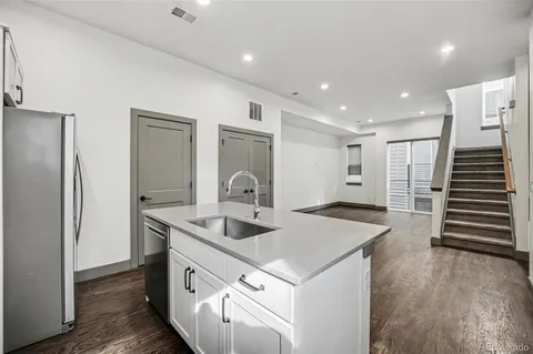 a kitchen with stainless steel appliances granite countertop a sink and a refrigerator