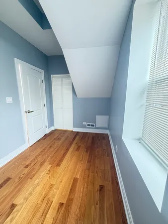 a view of empty room with wooden floor