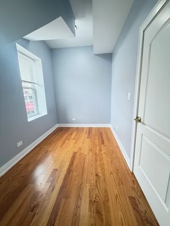a big room with wooden floor and pool table