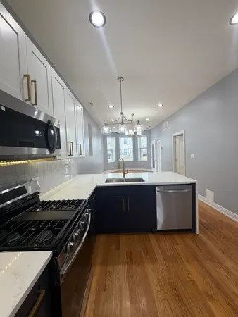 a large kitchen with granite countertop a stove and cabinets