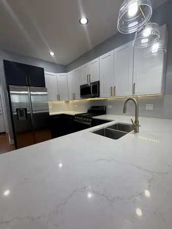 a kitchen with stainless steel appliances a sink a stove a microwave and cabinets