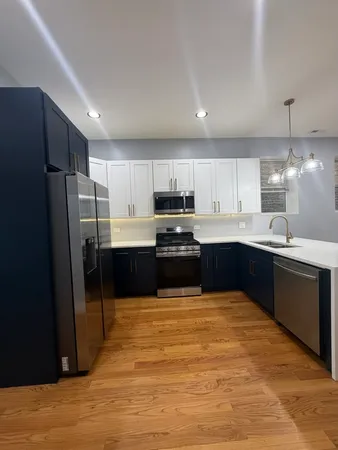 a large kitchen with kitchen island a sink stainless steel appliances and cabinets