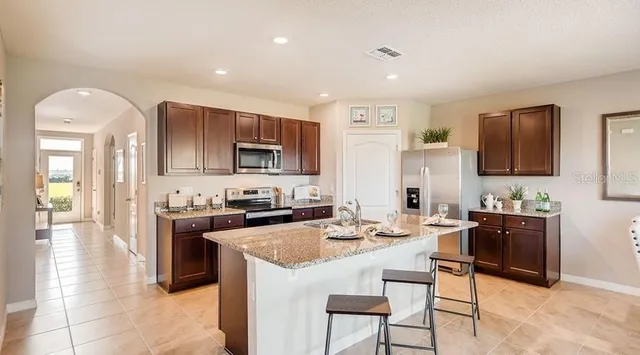 a kitchen with stainless steel appliances kitchen island granite countertop a sink and cabinets
