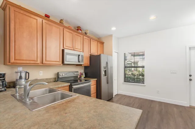 a kitchen with stainless steel appliances granite countertop a refrigerator sink and cabinets