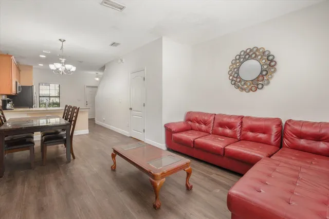 a living room with furniture a dining table and a chandelier