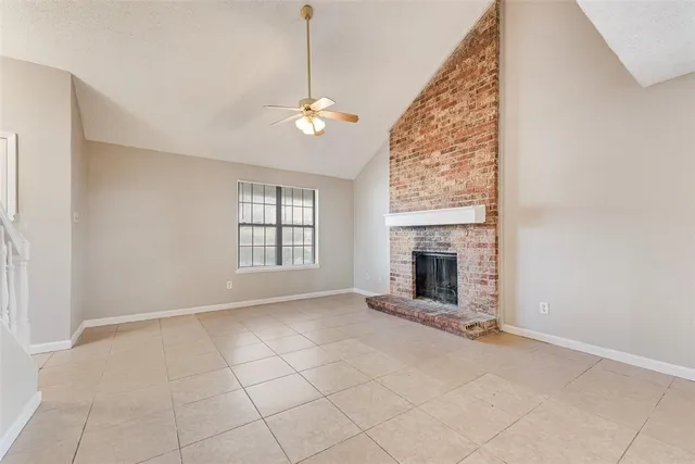 an empty room with windows and fireplace