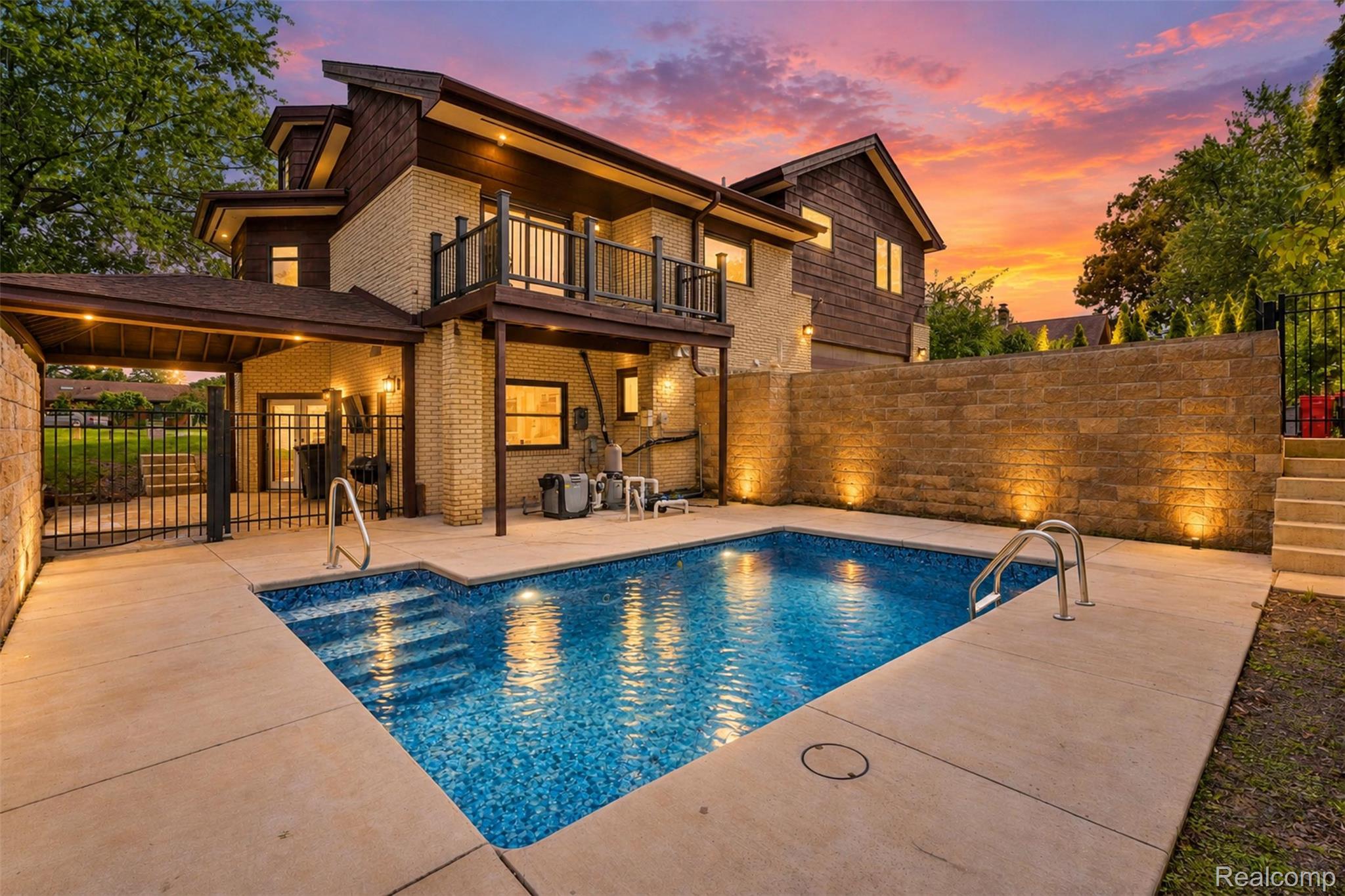 27507 Bell Road Southfield, MI 48034 - Photo 2 of 81 Exterior featuring a private swimming pool, concrete pool deck, a stone retaining wall with integrated lighting, and a second-story balcony