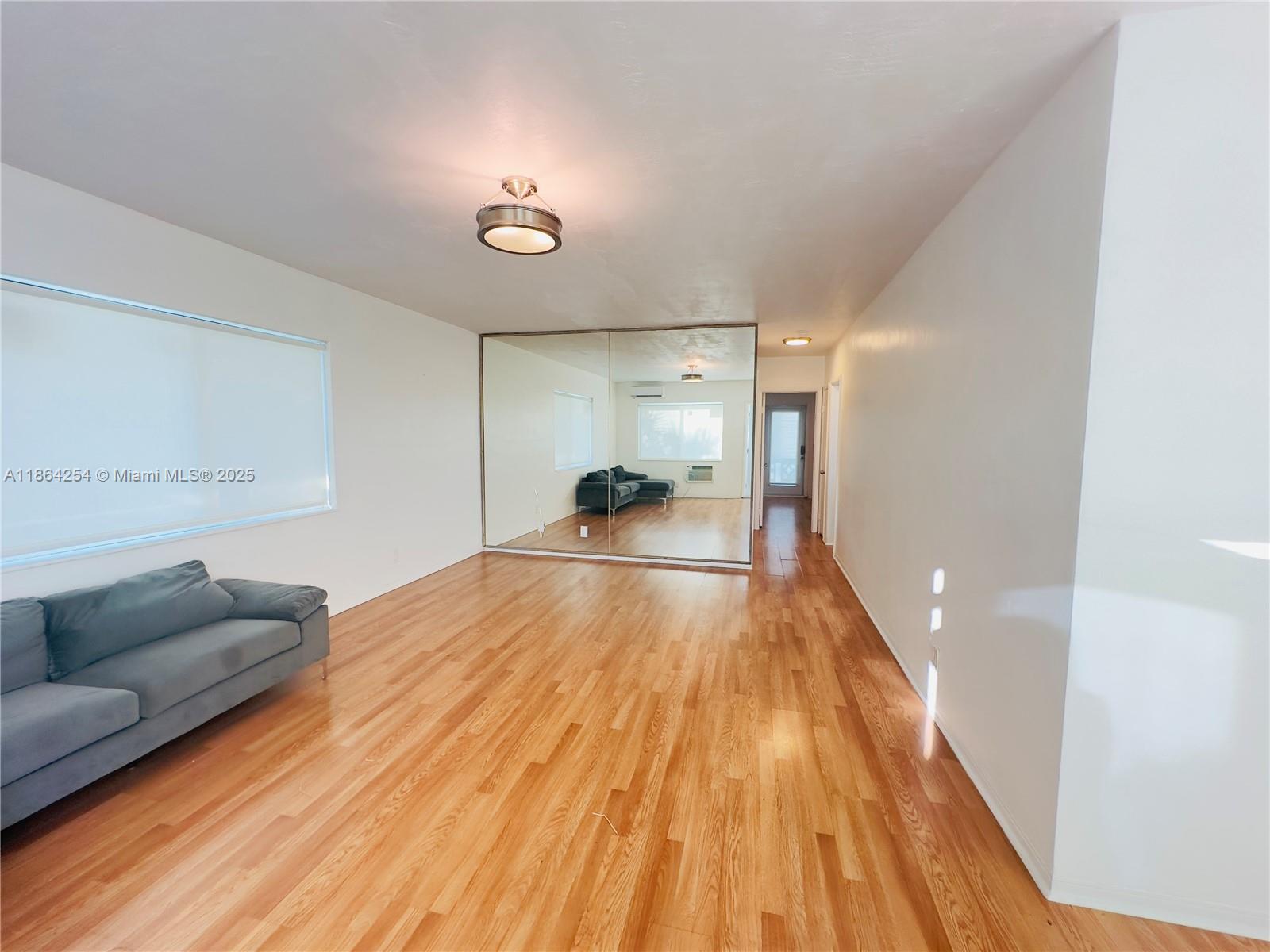 455 Golden Isles Drive, Unit 210 Hallandale Beach, FL 33009 - Photo 1 of 27 a living room with furniture and a wooden floor