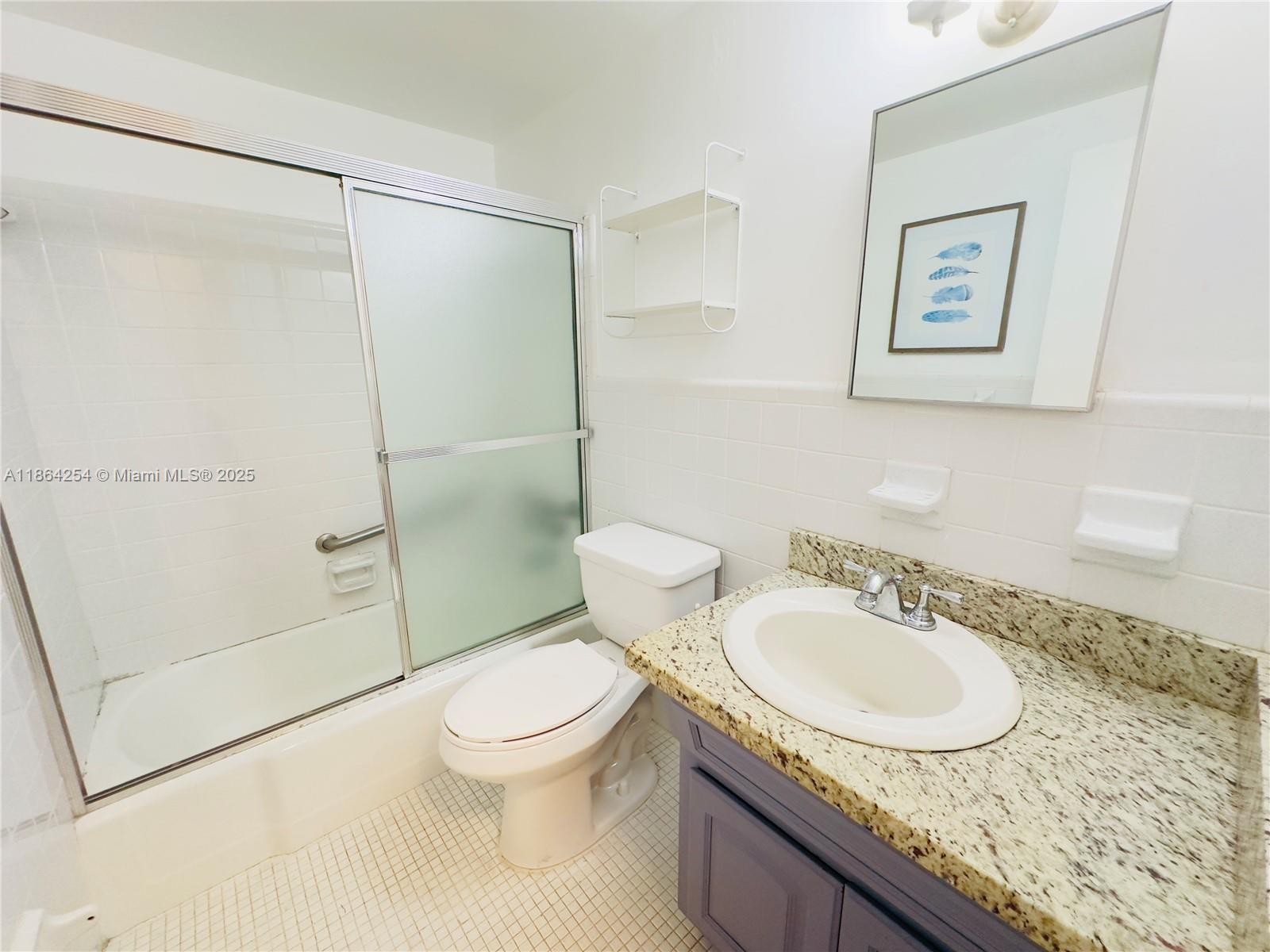 455 Golden Isles Drive, Unit 210 Hallandale Beach, FL 33009 - Photo 13 of 27 a bathroom with a granite countertop sink toilet and shower