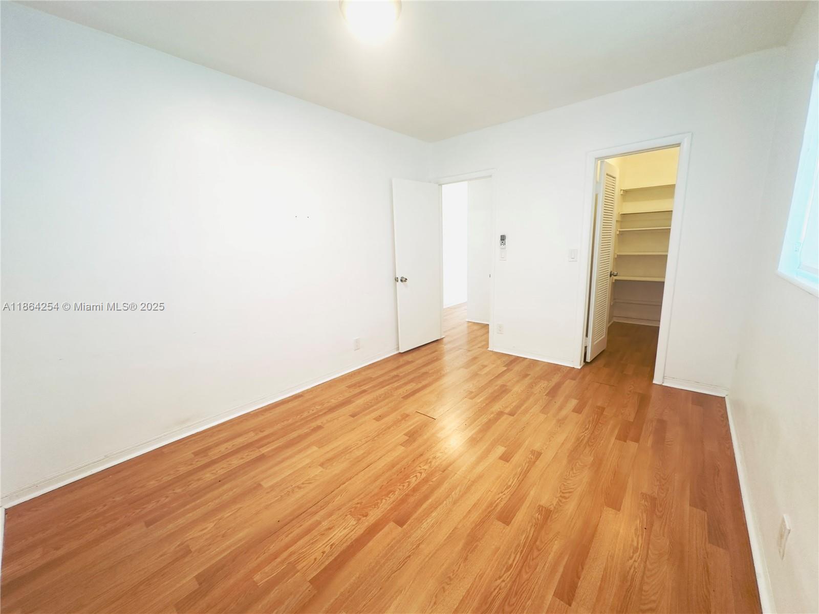 455 Golden Isles Drive, Unit 210 Hallandale Beach, FL 33009 - Photo 16 of 27 a view of empty room with wooden floor