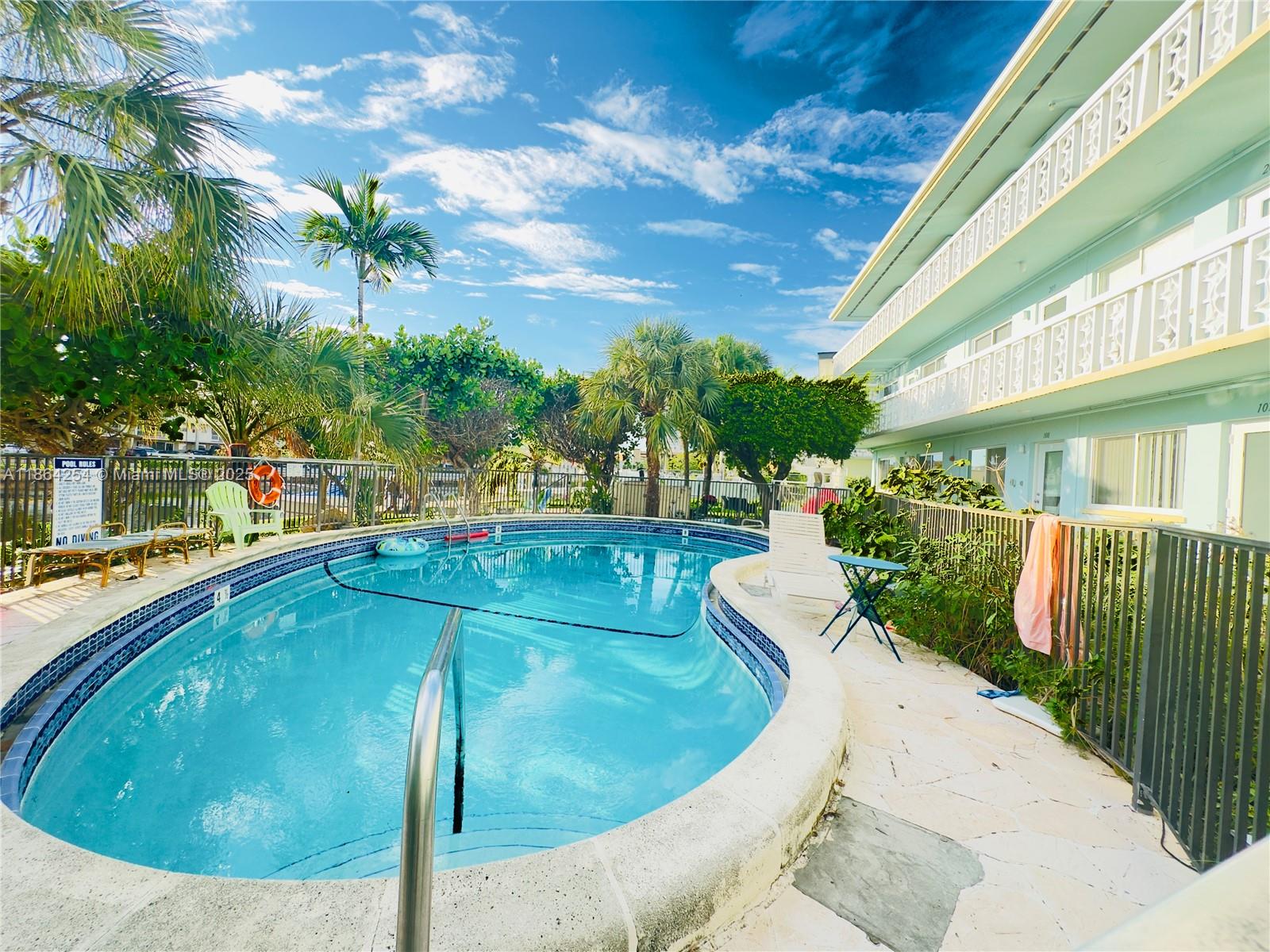 455 Golden Isles Drive, Unit 210 Hallandale Beach, FL 33009 - Photo 21 of 27 a view of a swimming pool with a patio